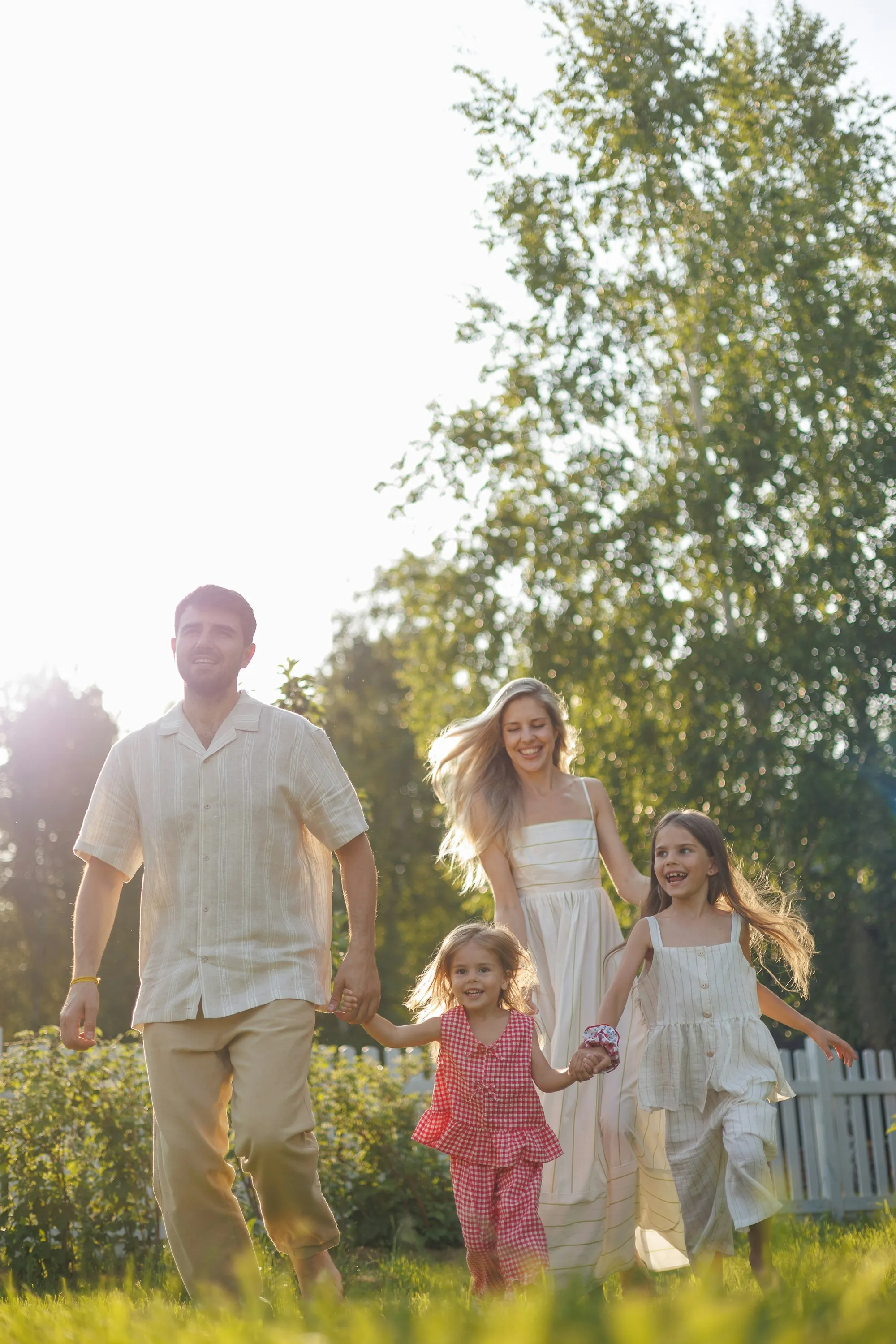 Parents and two children walking through a sunlit garden