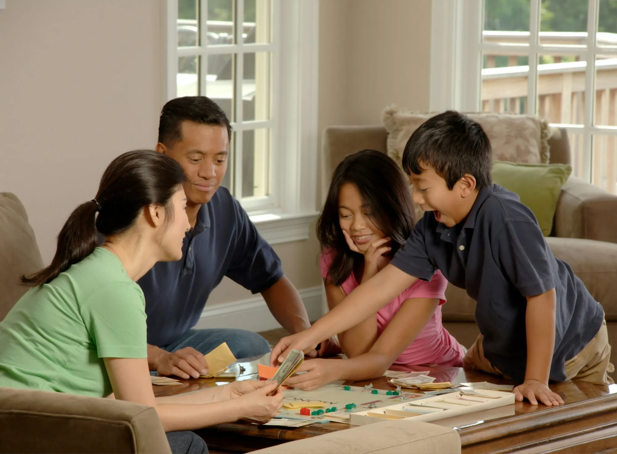 Family playing a board game together on the living room floor