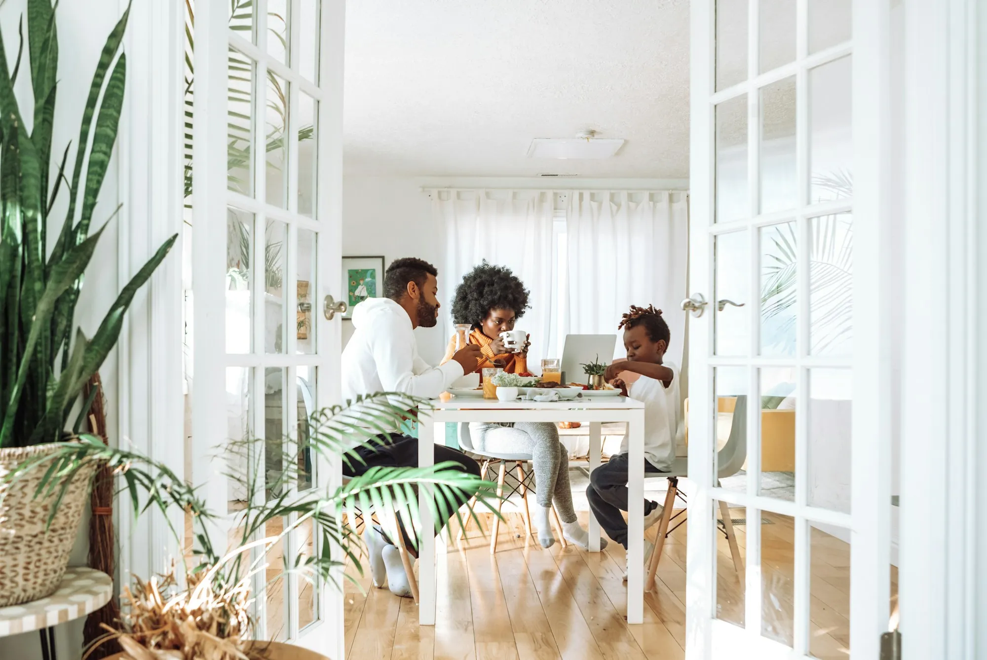 Family sitting around a dining table in a bright room, picturing life insurance for a stay-at-home parent in Highwood